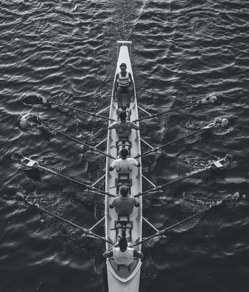 A team rowing a boat in a coordinated effort