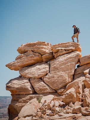 man looking over canyon