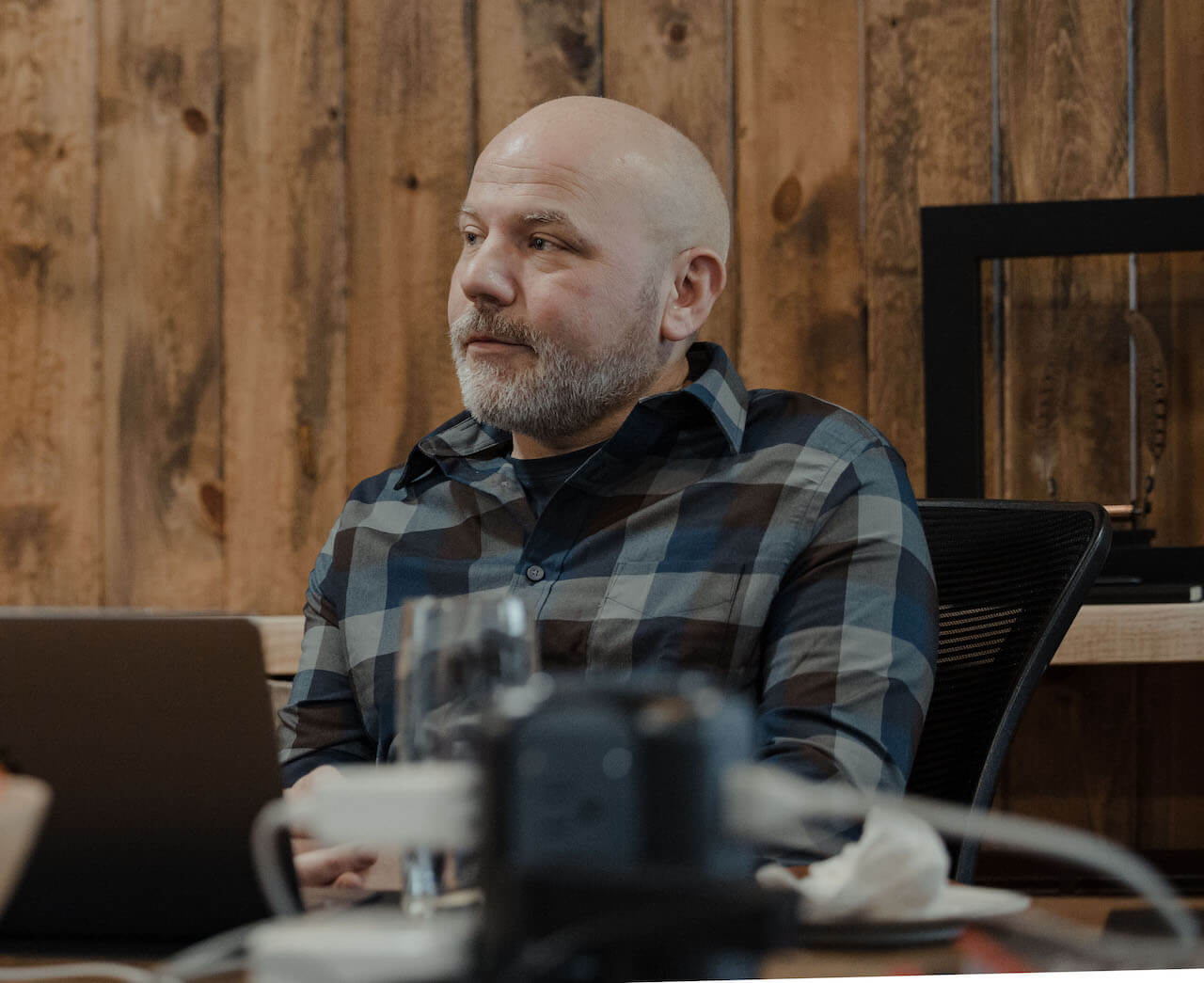 A person in a meeting listening to a colleague speak.