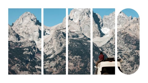 A van situated in front a mountain range.