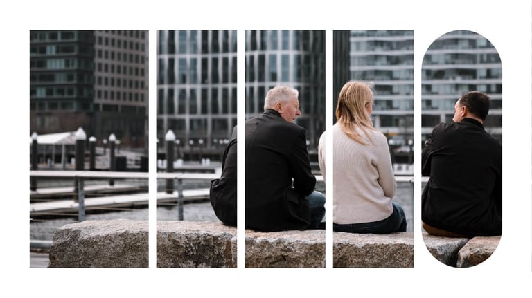 Three people seated outside of an office building, having a conversation.