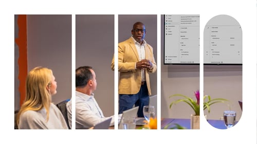A man leading a company meeting with the audience looking on.