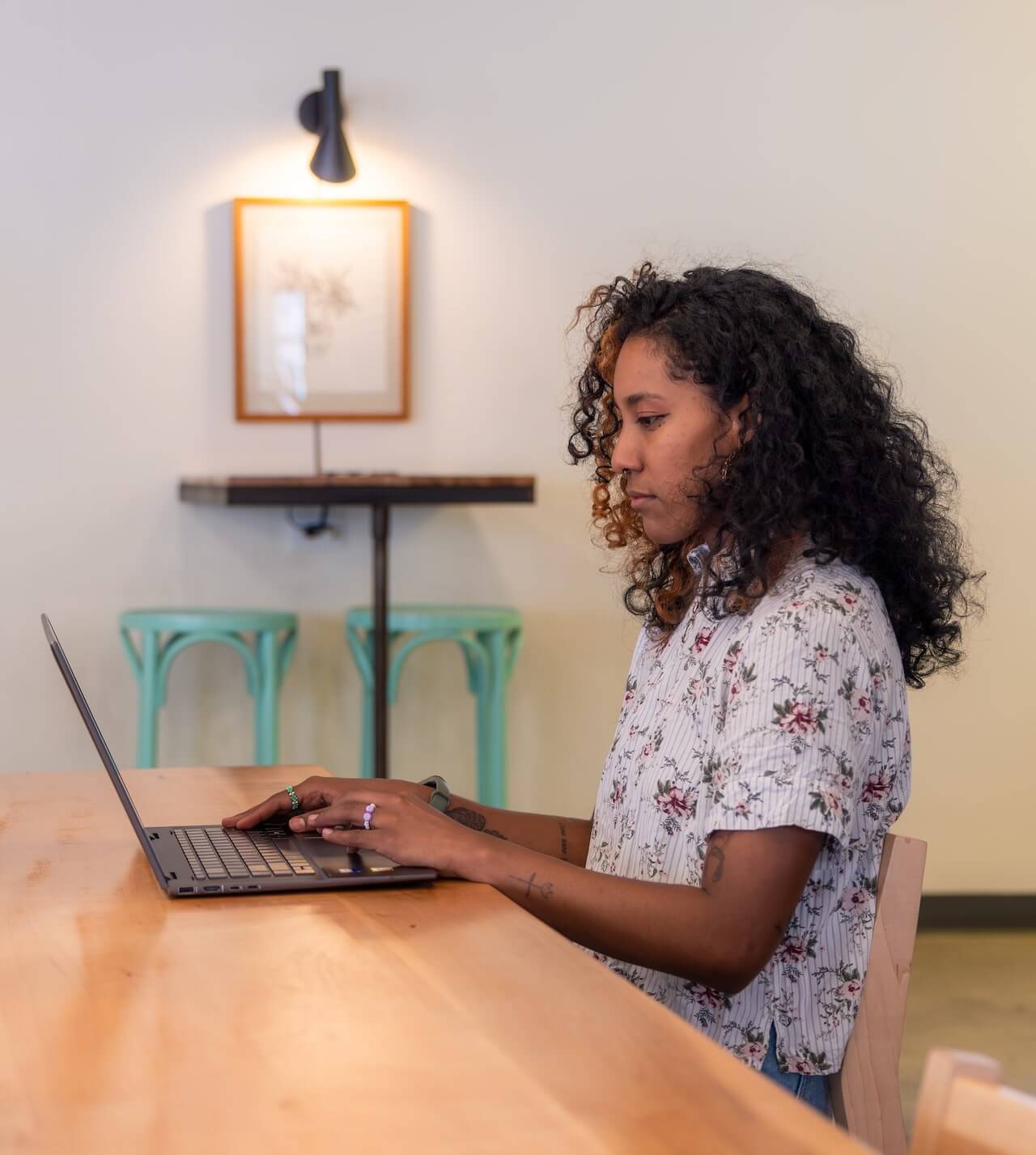 An employee seated at a table working on her laptop.