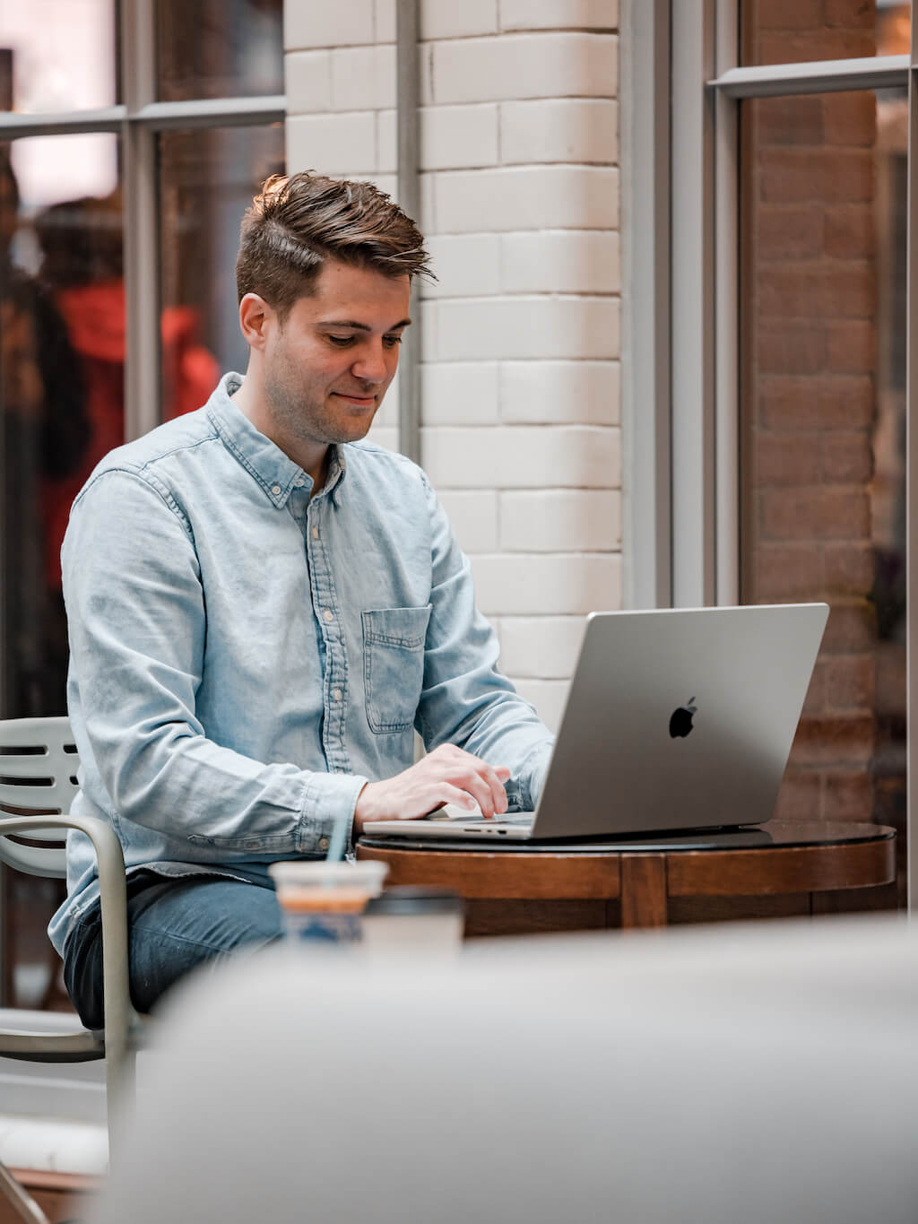 A main sitting outside working on his laptop.