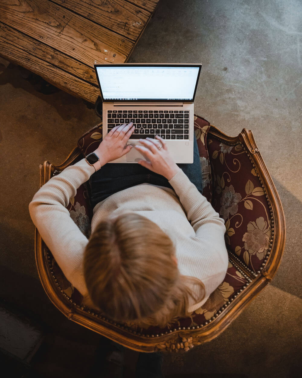 An overhead view of a woman working on her laptop.