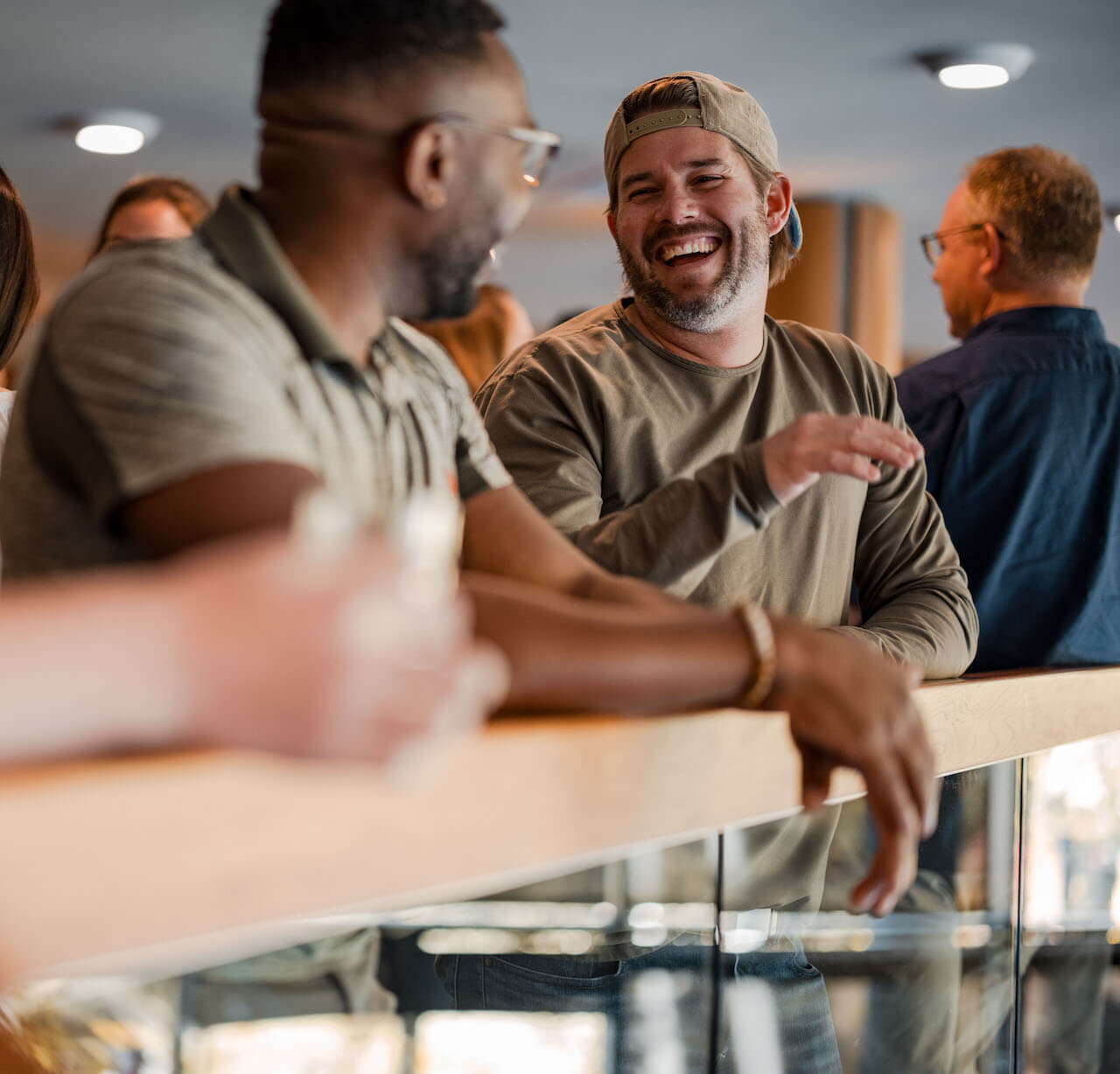 Two employees at a conference laughing and having a conversation.
