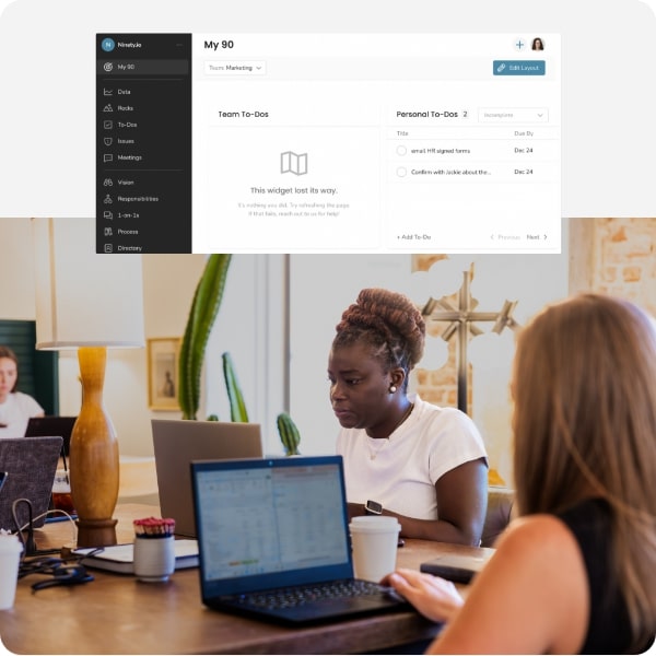 Employees at a table working on their laptop. Superimposed is a screenshot of the dark mode feature enabled in the Ninety app.