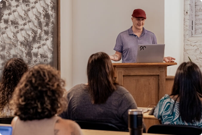 A speaker in front of a group giving a presentation.