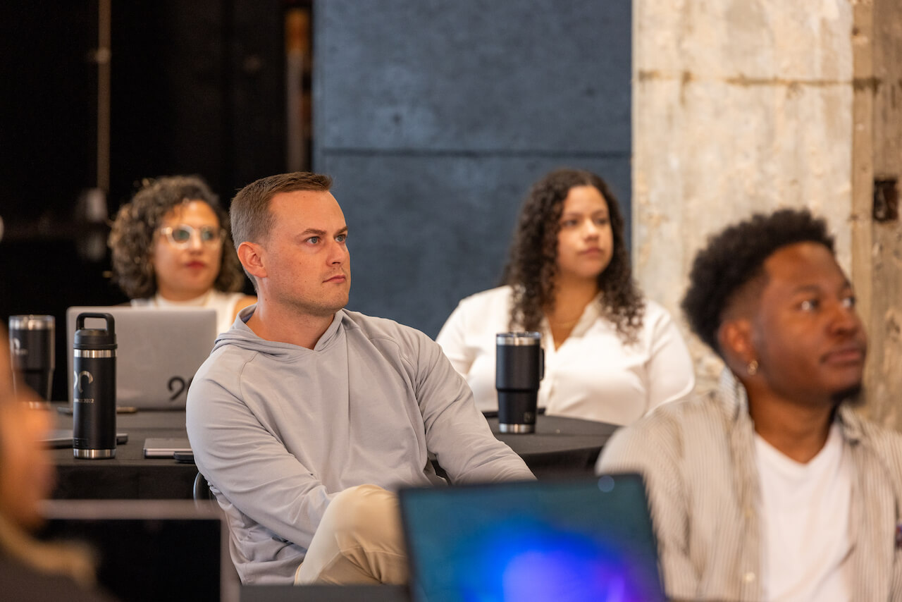Ninety employees seated during a presentation, listening intently to the speaker.