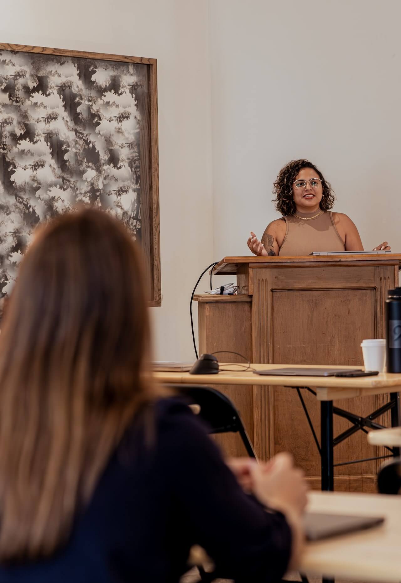 A woman standing at a podium speaking to an audience.