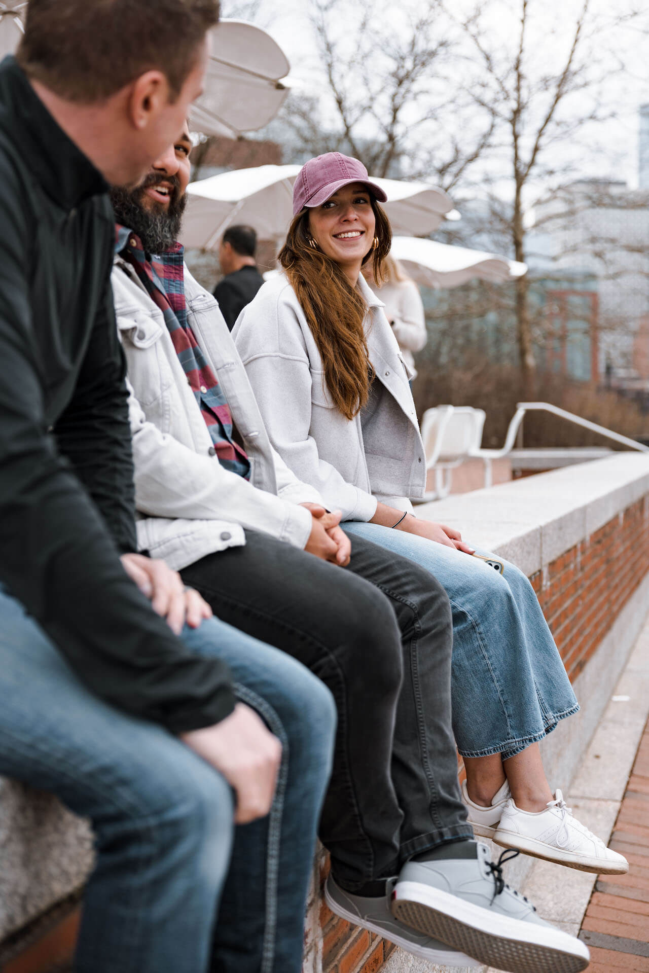 Employees seated outside smiling and having a conversation.