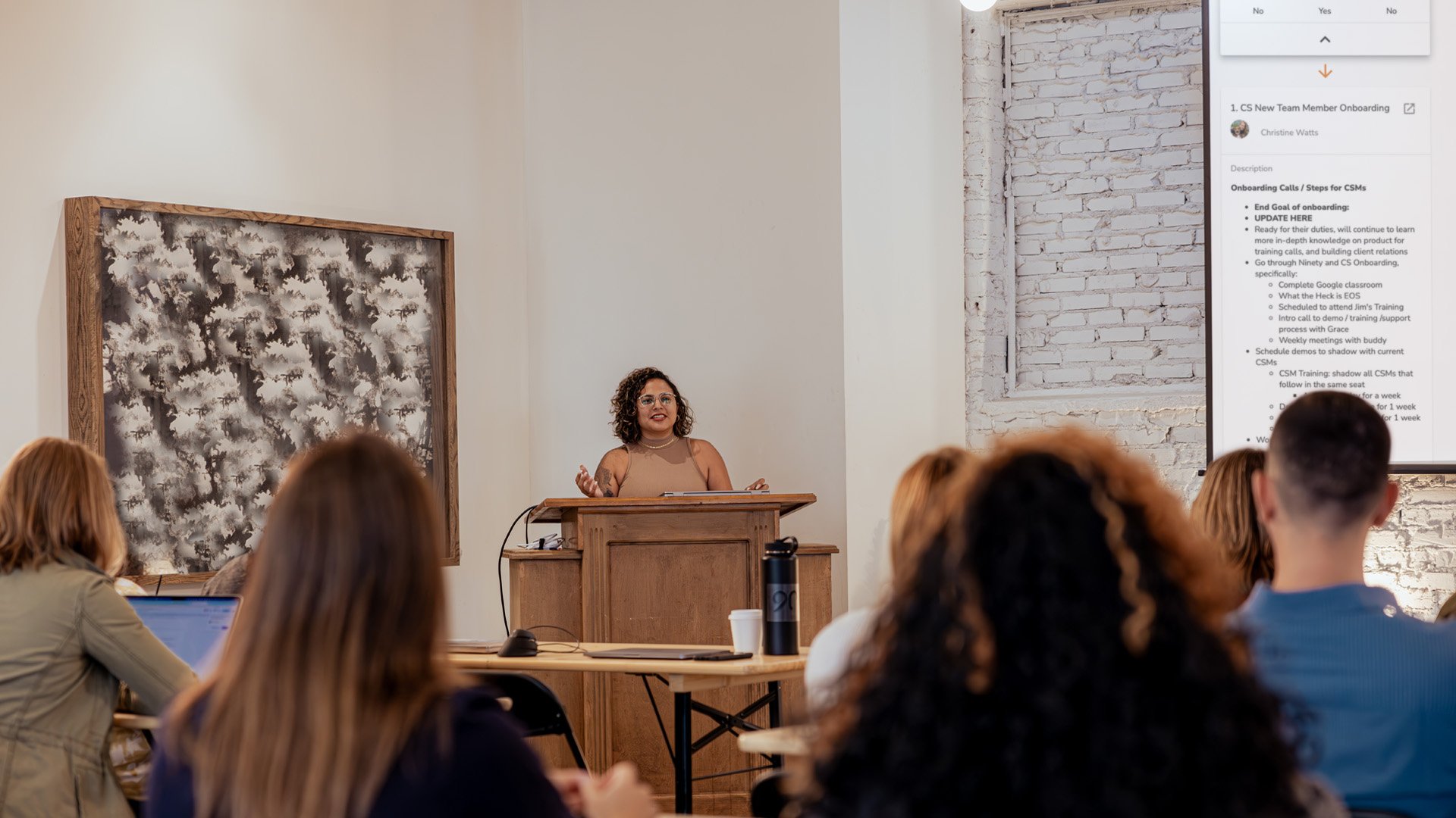 A leader presents to her team in a conference room. 