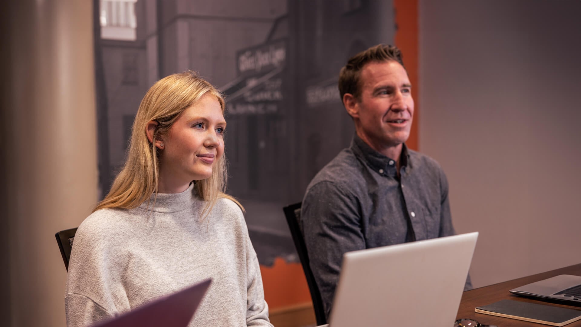 A man and woman sitting at a conference table.