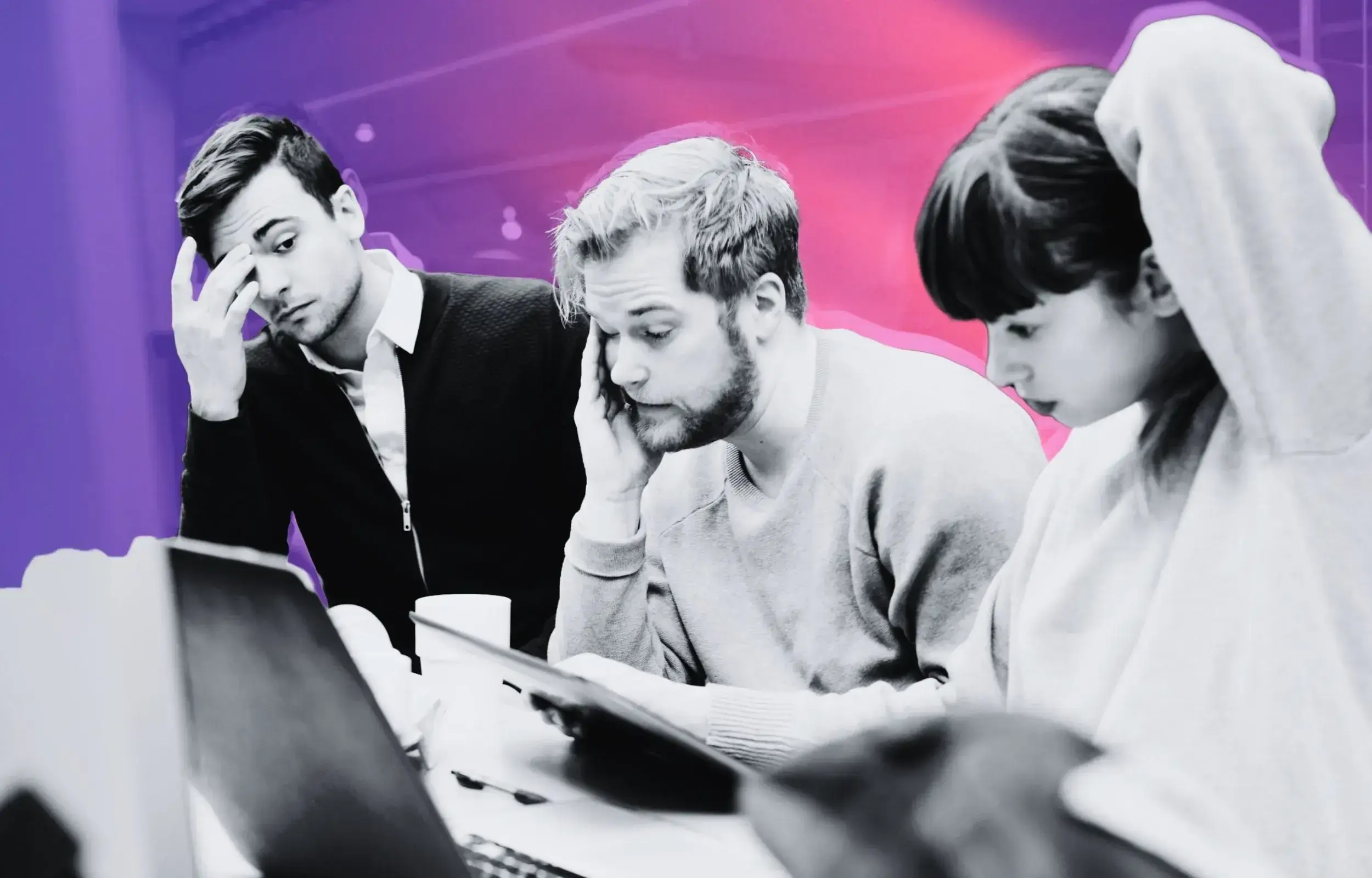 Black-and-white photo of three stressed entrepreneurs with a pink and purple gradient background, one holding his head in frustration while looking at a laptop.