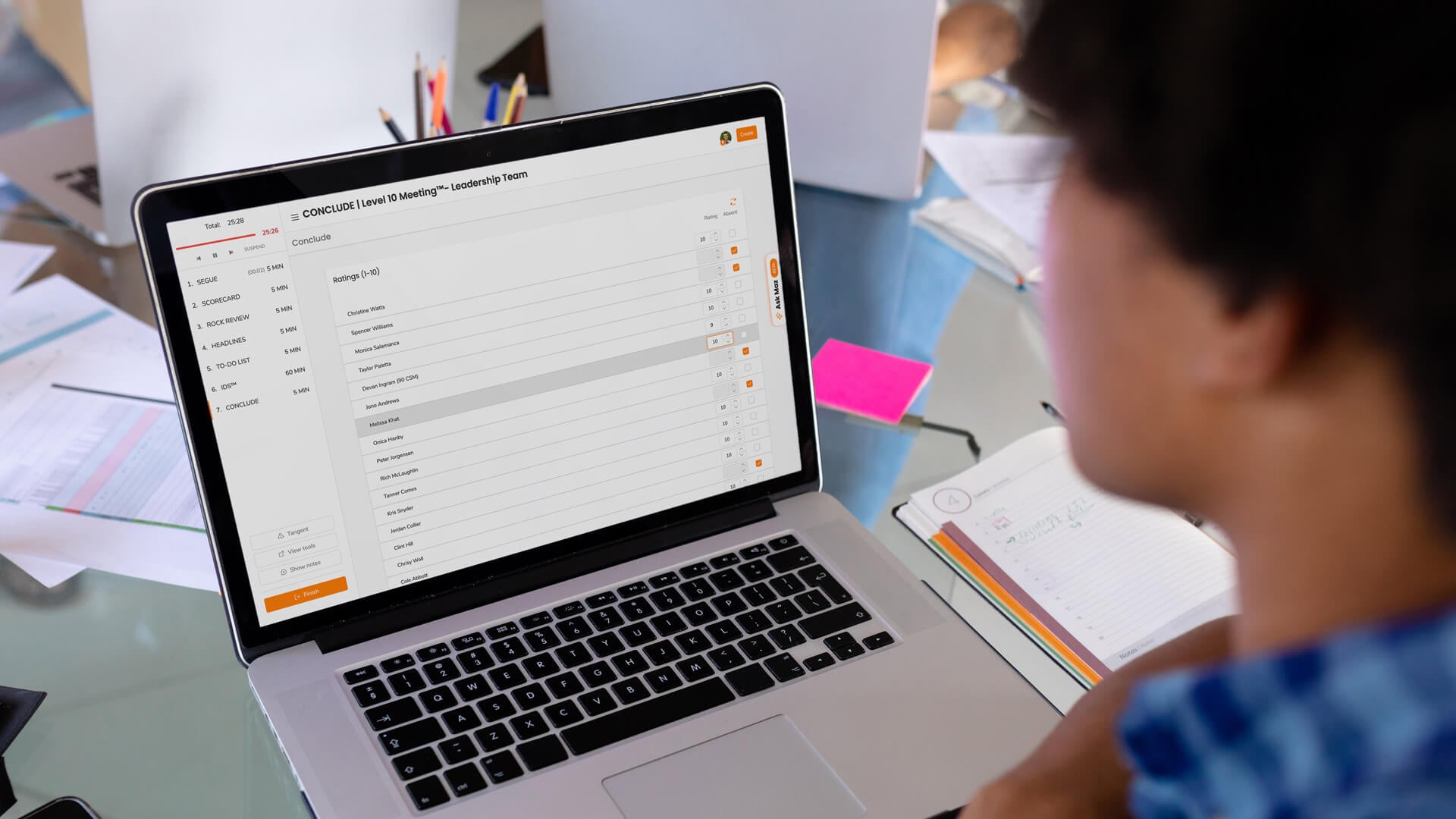 A person staring at a laptop screen with a Level 10 Meeting Needs Rating EOS