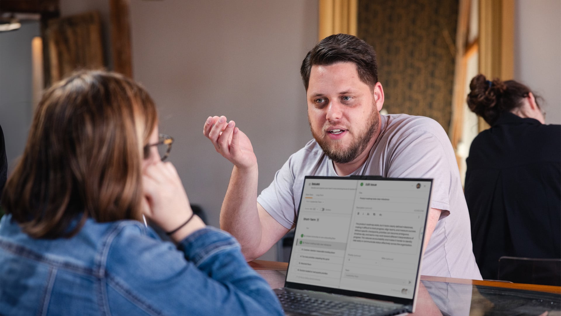 Two people talking while looking at a laptop screen with Ninety's app on the screen.