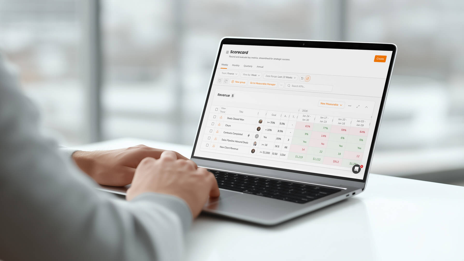 Someone typing on a laptop that shows an EOS Scorecard.