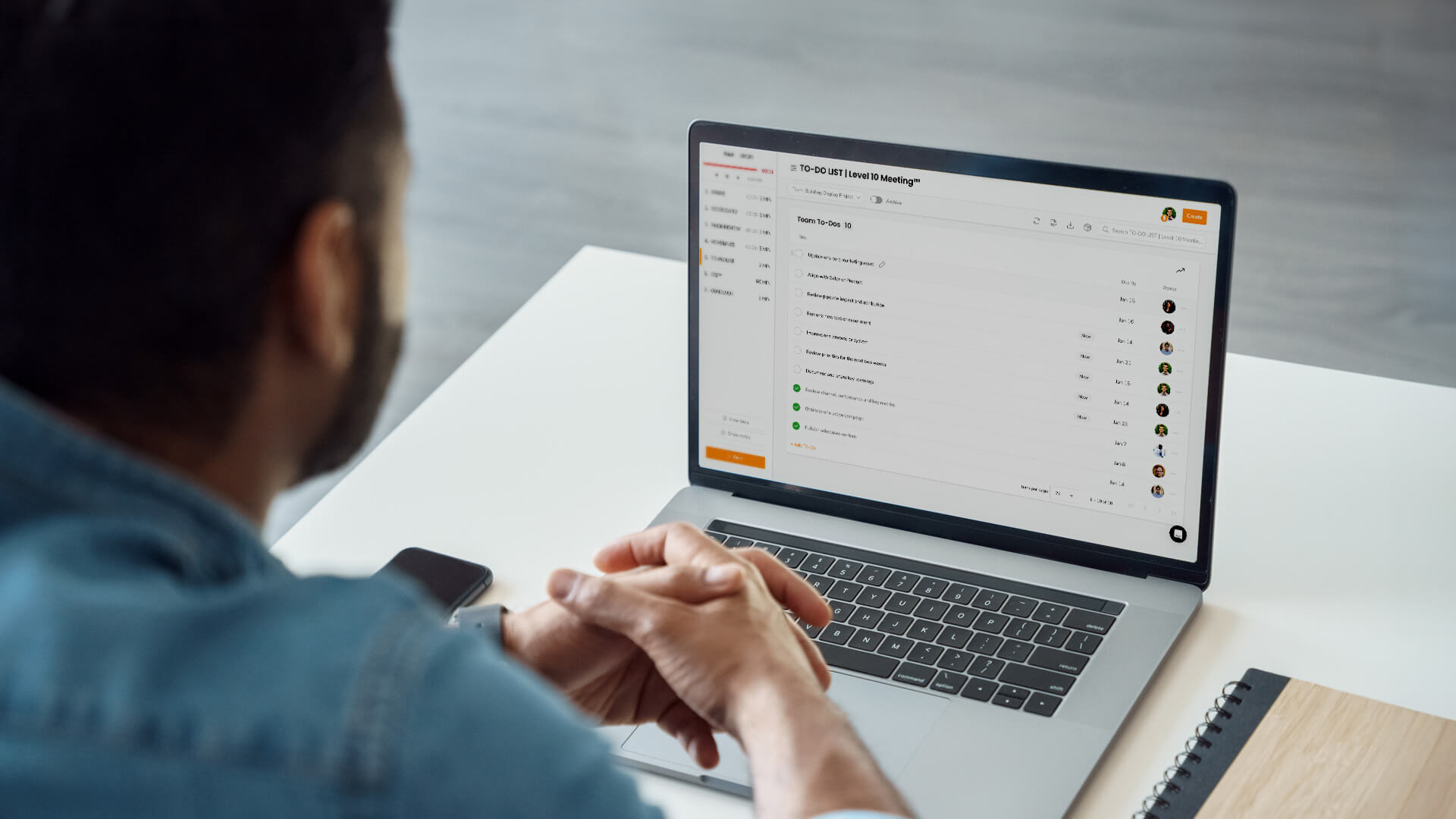 A man sits at a desk with a laptop in front of him.