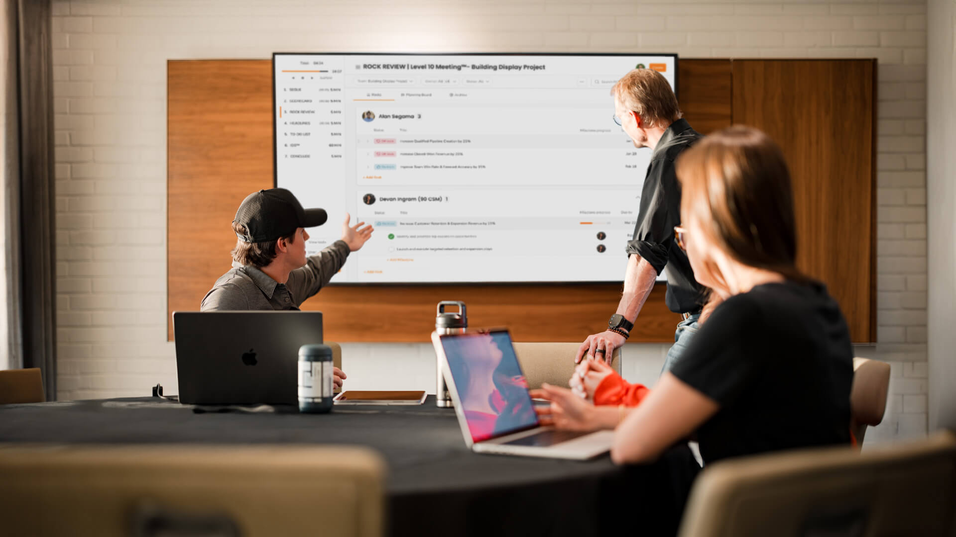 Multiple people look at a large screen in a conference room.
