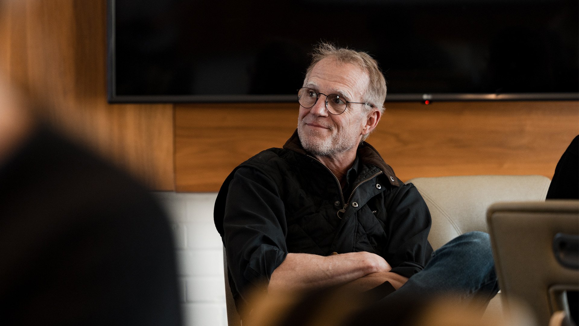A man looks to the side with a slight smile.