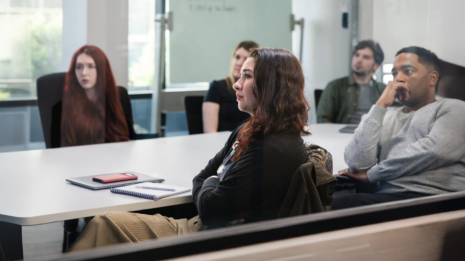 Several people sit around a conference room table.