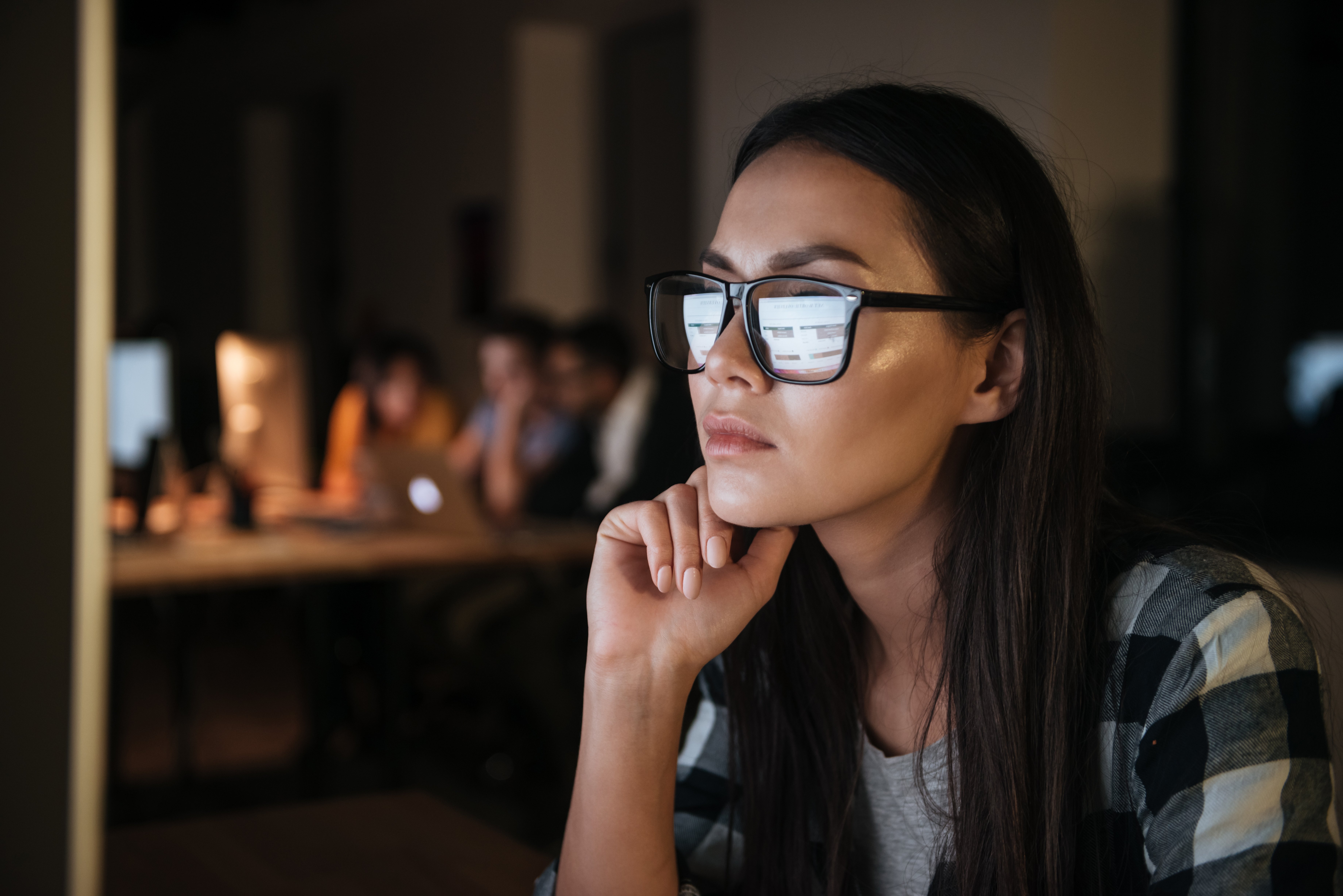 serious-businesswoman-wearing-glasses-working-late-at-night-in-office-with-computer-lo-SBI-302894188